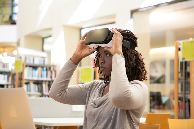 An Argentinian student using a VR headset in a classroom setting dedicated to virtual learning. The headset displays an educational simulation, and the student is interacting with the virtual environment.